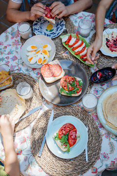 Overhead view of colorful Mediterranean family breakfast with sandwiches eggs pancakes and fresh food