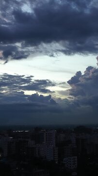 Storm Clouds Illuminated by vertical Sunset Over City Buildings