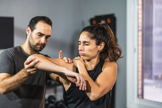 Therapist assisting woman with shoulder physiotherapy rehabilitation