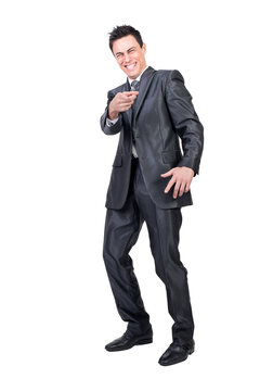 Full body of happy male executive manager pointing at camera and laughing on funny joke in studio against transparent background