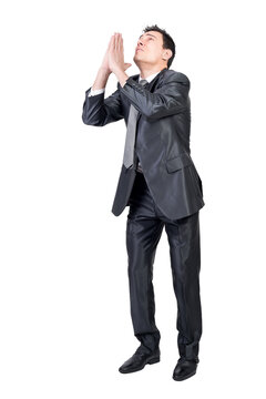Full body of male entrepreneur in formal suit keeping hands together and pleading for help against transparent background