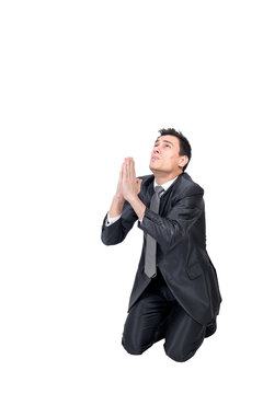 Full body of helpless male entrepreneur in formal suit keeping hands together while begging for forgiveness against