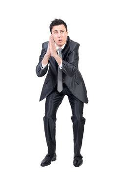 Full body of desperate male model in formal suit keeping has together frowning and asking favor in studio against transparent background