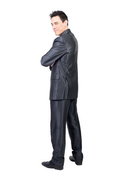 Full body of content male in formal suit looking over shoulder at camera with squinting eyes isolated on transparent background