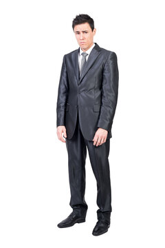 Full body of sad young male manager with short dark hair in elegant suit and tie and looking at camera with frustration