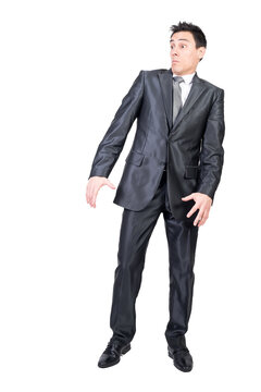 Full length of surprised young male entrepreneur with dark hair in formal suit and tie looking away with astonished face