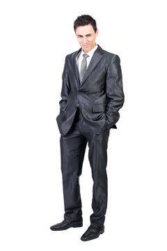 Full body of seductive male in formal suit looking at camera with smirk while standing with hands in pockets isolated on transparent background in studio