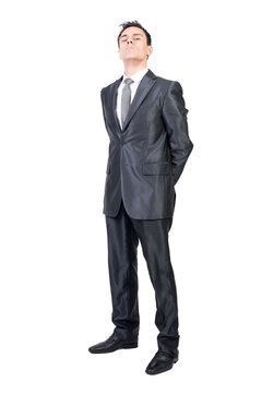 Full body of stringent male in formal suit looking at camera with hands behind back isolated on transparent background in studio