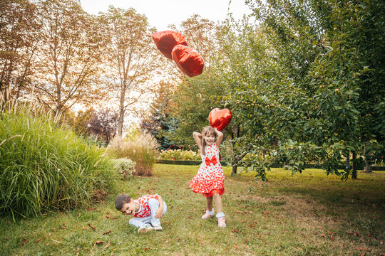 Children Enjoy Summer Holiday in the Garden With Heart-Shaped Balloons on Valentine's Day