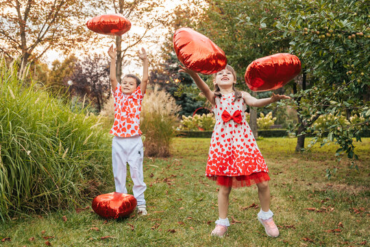 Children Celebrate Summer in the Garden While Playing With Red Heart-Shaped Balloons During a Holiday Filled With Love and Joy