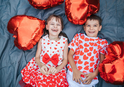 Children Enjoy Summer Fun With Heart-Shaped Decorations on a Blanket During a Holiday Celebration