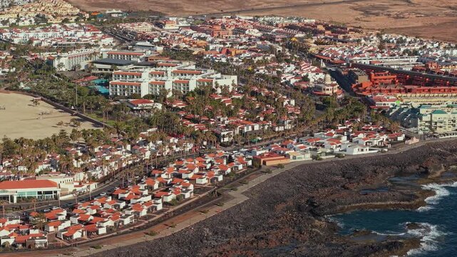 Aerial view of Caleta de Fuste, a resort town on Fuerteventura, one of Spain&rsquo;s Canary Islands, Spain. Drone POV exploration of the town architecture and the coastal lanshaft.
