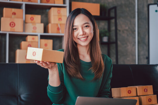 Asian Woman Selling Online from Home Office with Shipping Boxes