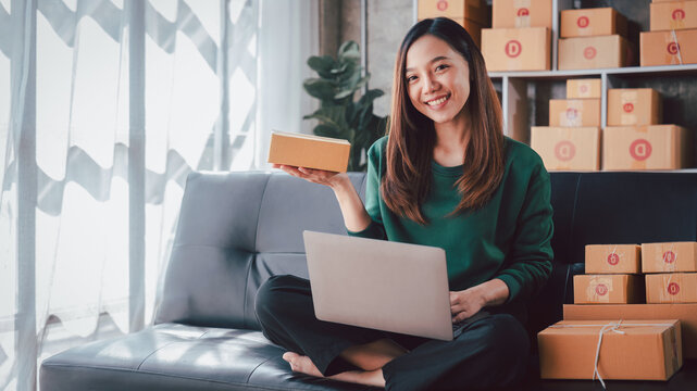 Asian Woman Entrepreneur Working from Home with Laptop Preparing