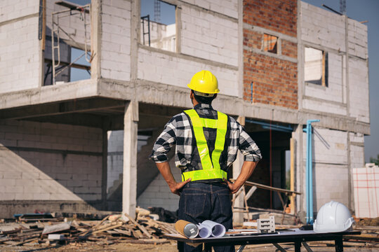 Asian Adult Construction Worker Inspecting Building Progress Wea