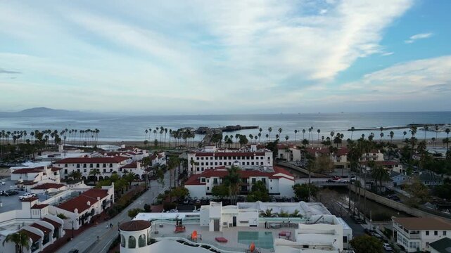 Aerial moving back over State Street from Cabrillo Blvd. in Santa Barbara, California. With views of the beach, Stearns wharf, Spanish architecture and the Channel Islands in the distance.