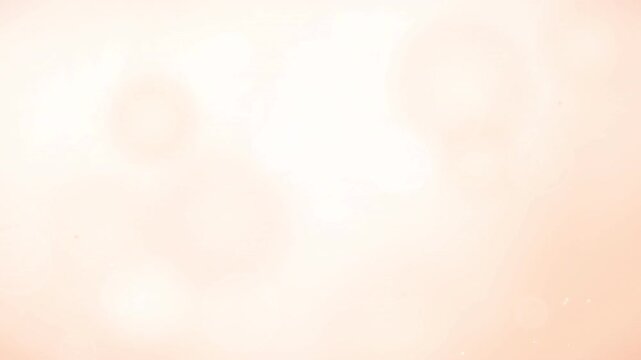 A soft abstract background features a glowing peach and white bokeh light effect texture.