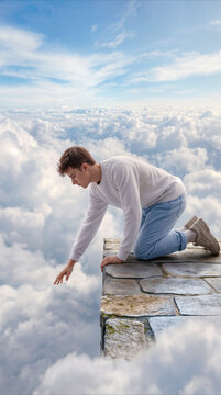 Person reaching out from stone ledge above clouds. Surreal concept of reaching for the impossible or exploring heavenly heights.