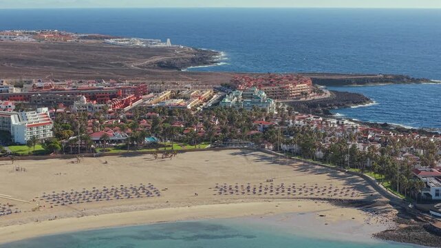 Aerial view of Caleta de Fuste, a resort town on Fuerteventura, one of Spain&rsquo;s Canary Islands, Spain. Drone POV exploration of the town architecture and the coastal lanshaft.