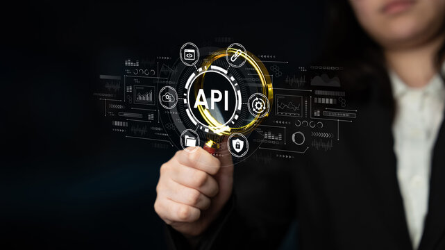 Focused Hand with Magnifying Glass Over API Concept and Digital Symbols Representing Data Management and Technology in Dark Background. Entropy.