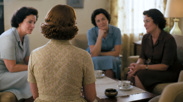 Women gathered for a small group discussion at home, representing community support, friendship, conversation and social connection