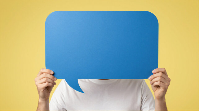 Person holding a blue speech bubble in front of face
