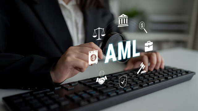 Hands Using Keyboard for Anti-Money Laundering Concept with Financial Icons and Symbols Superimposed on Office Desk Background. Glyphic.