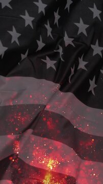 merican black and white flag waving burning, with the smoke and particles of fire visible