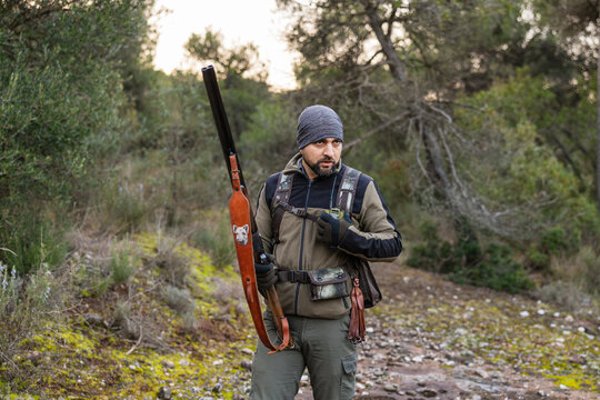Hunter standing ready with shotgun in nature
