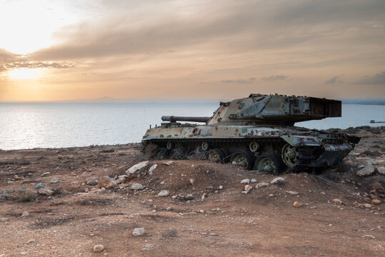 Rusted tank wreckage overlooking the sea, symbolizing past conflict and peace