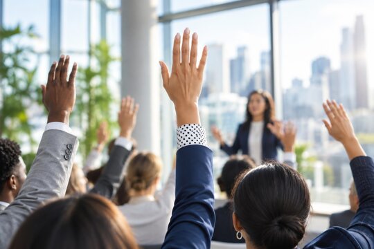Business people in a workshop raising hands to ask questions during a presentation.