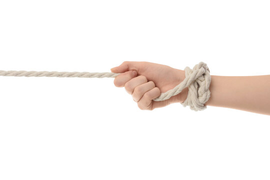 Struggle and resistance concept, hand tied with rope pulling against tension and pressure in a metaphor for conflict or being held back in life