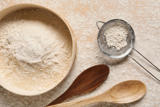 Baking and culinary preparation, flour in wooden sieve with metal strainer and spoons on rustic kitchen table for homemade bread and pastry cooking