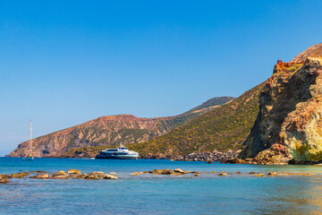 High-speed passenger ferry sailing in the blue Tyrrhenian sea past volcanic cliffs of Vulcano...
