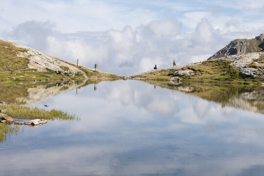 Le lac des Moutons aux Arcs, en Savoie : un lac d'altitude dans les Alpes fran&ccedil;aises, entour&eacute; de montagnes rocheuses et de vaches. Reflets des montagnes &mdash; dont le mont Blanc &mdash; dans les eaux du lac.