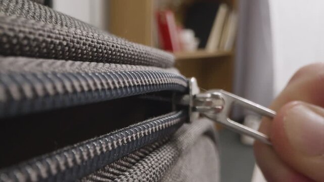 Close up hand of a young woman closing her gray suitcase. Close Up Of Person At Home Closing And Zipping Up Suitcase Ready For Summer