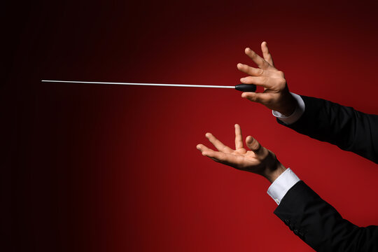 Male conductors hands on dark red background