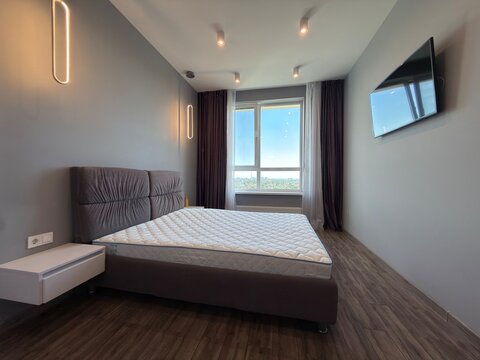 Modern Minimalist Bedroom Interior with Large Window and Wall Mounted TV