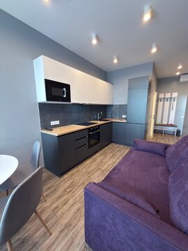 Modern Open Plan Kitchen and Living Room Interior with Purple Sofa