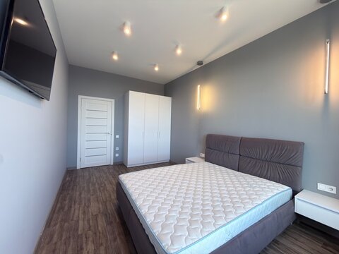 Modern Minimalist Bedroom Interior with Double Bed and Contemporary Lighting