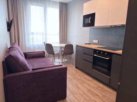 Modern Open Plan Kitchen and Living Room Interior with Purple Sofa