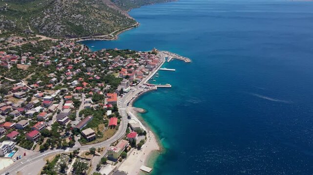 Aerial view of small coastal town with harbor and beach
