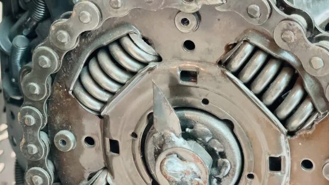 extreme close-up of worn metal clutch and roller chain sprocket assembly with interlocked teeth, textured steel surfaces, grease cz, kladno, americka, 8.9.26