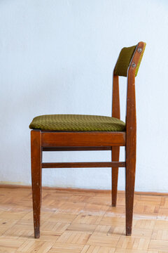 Vintage wooden chair on old parquet floor in an empty apartment, outdated interior requiring renovation and remodeling