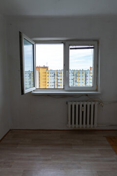 Old apartment interior in poor condition with outdated walls, exposed wiring and worn flooring, empty room requiring renovation and remodeling