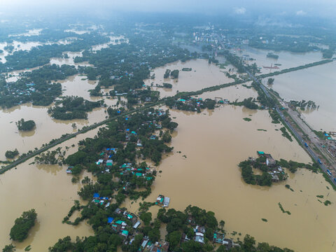 11 July 2026: Aerial view of a flooded landscape with submerged houses and trees surrounded by rising floodwaters in a rural area.