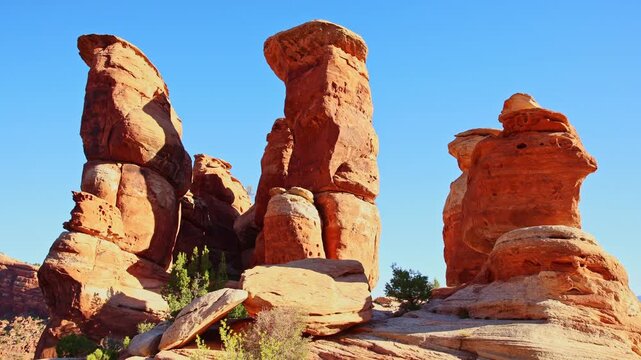 Massive weathered sandstone rock spires rise vertically under clear skies along Devils Kitchen Trail in Colorado National Monument