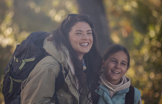 Mother and daughter smile during outdoor hiking activity