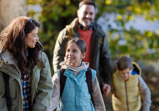 Family enjoys a walk in the park during autumn