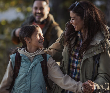 Family enjoys a walk in the park during autumn